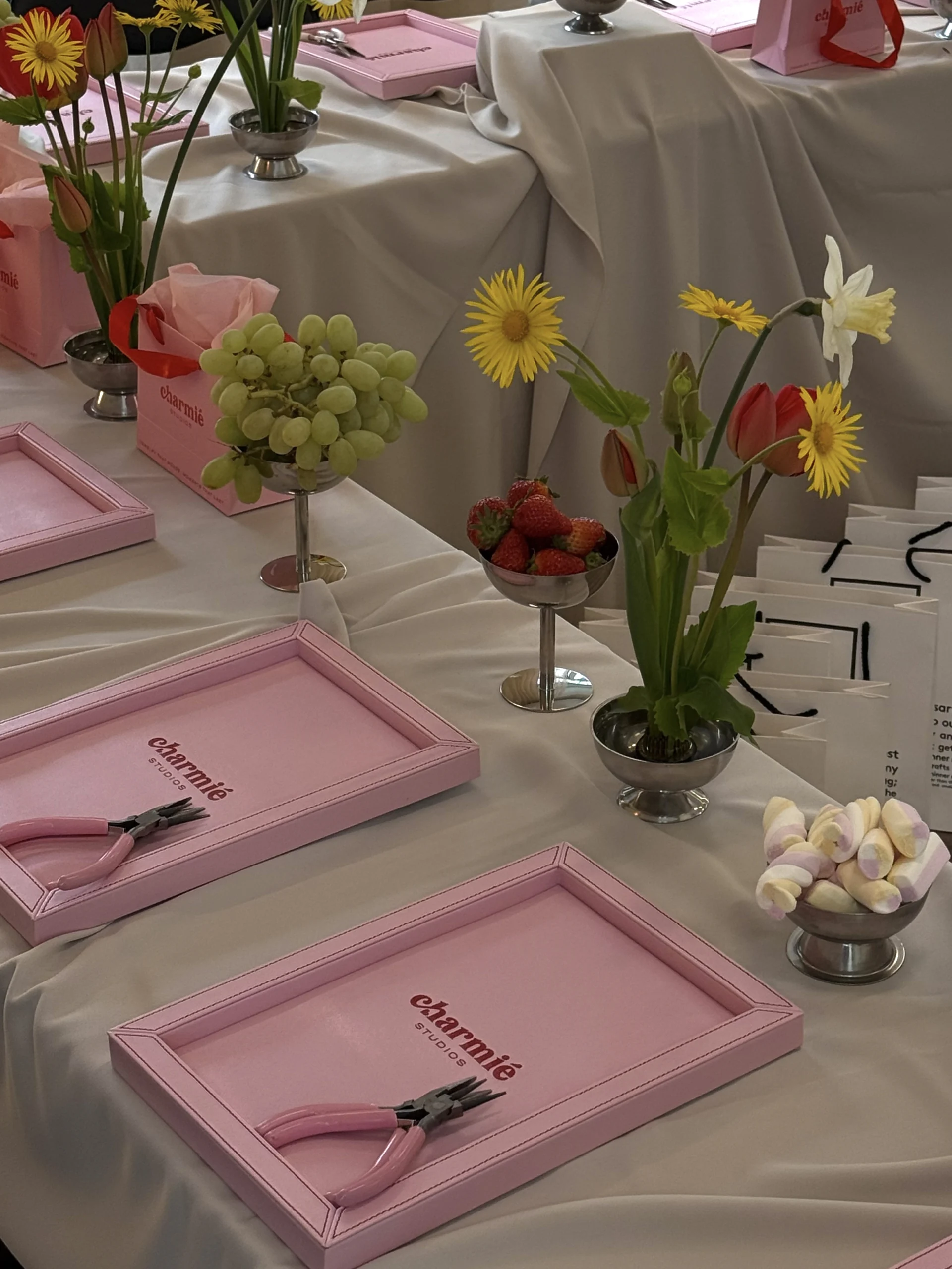 Charmié pink gift bag and pliers at an event setup